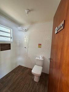 a bathroom with a white toilet and a door at Chácara em Piracaia in Piracaia +79 photos