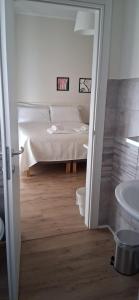 a bedroom with a bed and a bathroom with a sink at Affittacamere Risorgimento in Lecco