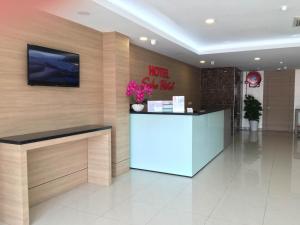 a hotel lobby with a reception desk with flowers at Soho Hotel Semenyih in Semenyih