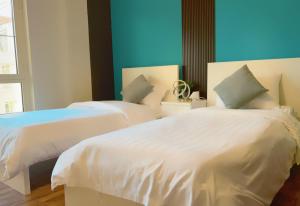 two beds sitting next to each other in a bedroom at مارينا موج البحر غرفتين اطلاله بحريه عوائل فقط Marina sea waves in King Abdullah Economic City