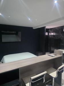 La CoyoteraにあるCataleya Suites Cassandraのベッドと机と椅子のある寝室