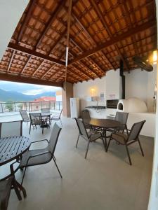 a dining room with tables and chairs and a kitchen at Luxury Studio Ubatuba in Ubatuba