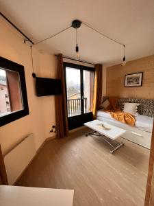 Una habitación con una cama y una mesa dentro. en Joli studio hypercentre, en Les Carroz d'Araches