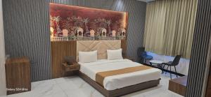 a bedroom with a bed and a table and a chair at Premvakita restaurant and hotel in Ratlām