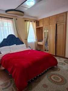 a bedroom with a red bed with a blue head board at Presitige Vacation Stay in Nairobi