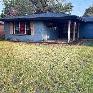 a blue house with a lawn in front of it at Raider Retreat-Your TTU Basecamp in Lubbock