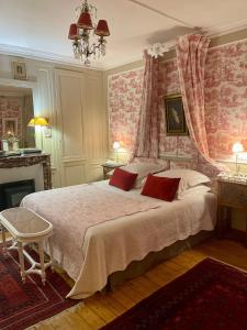 a bedroom with a large bed with red wallpaper at VILLA la GLORIETTE in Rouen