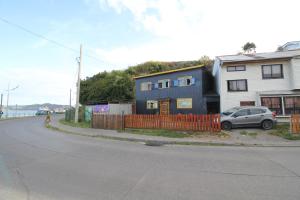 a house on the side of a street with a car at Hostal La Casa de Sandrita in Castro