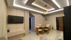a dining room with a table and a tv on a wall at Sharm Hills Luxury Pool View in Sharm El Sheikh