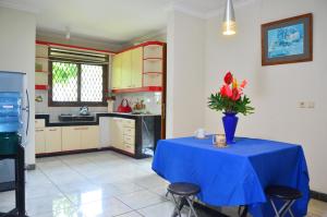 a kitchen with a blue table with a vase of flowers on it at Villa Buenavista Puncak in Puncak
