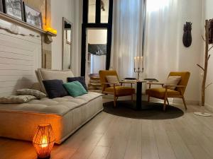 a living room with a couch and a table and chairs at Le cocon Bourbonnoux in Bourges +13 photos