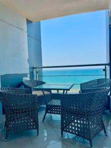 a table and chairs with a view of the ocean at ALEX HOMES - Gleem Luxury Apartments with Direct Sea View in Alexandria