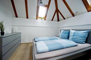 a bedroom with a bed with blue and white sheets at Charmantes Ferienhaus mit Garten, Kamin & Teich in Hirzenhain