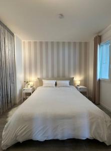 a bedroom with a large white bed with two tables at La Rondine in Gravedona