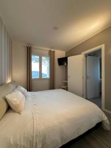 a bedroom with a large white bed with a window at La Rondine in Gravedona