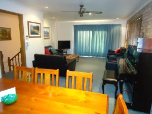 uma sala de estar com uma mesa e um sofá em Dalmeny Shores em Dalmeny