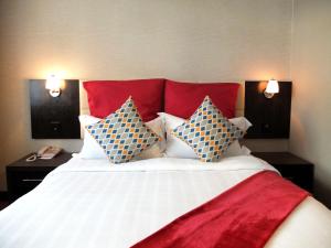 a bedroom with a large bed with a red headboard at The Mark's Lodge in Sandakan