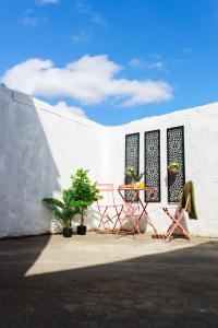 un tavolo e sedie di fronte a una parete bianca di Lohia Nights a Middlesbrough