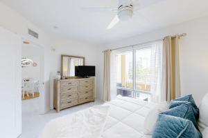 a bedroom with a bed and a dresser with a mirror at Luau II 6229 in Destin