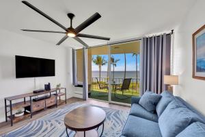 a living room with a blue couch and a flat screen tv at Hale Kai O'Kihei 309 in Kihei