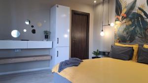 a bedroom with a yellow bed and a cabinet at Къща за гости Рилски чардак in Sapareva Banya