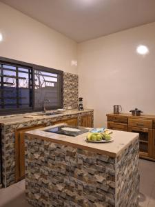 a kitchen with a stone island with a plate of fruit on it at Blue Villa in Mbour