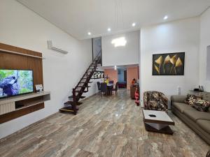 ein Wohnzimmer mit Sofa und Fernseher in der Unterkunft Casa de Praia Planeta Guarajuba in Guarajuba