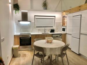 Una cocina con una mesa y sillas en una cocina. en Zeca Holidays -Atalaia Fall Mezanine Ideal para trabalhar, en Lourinhã