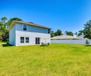 a home with a large yard with a white house at Cozy Villa with Private Garden, Pet Friendly, 14 Guest in Palm Coast