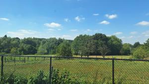 a fence in front of a field with trees at Peaceful Countryside Escape for Leisure or Work, Near Brussels in Dilbeek