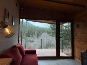 una sala de estar con una gran puerta corredera de cristal en RIO-ABAJO Cabañas frente al RIO MELIQUINA, en Villa Meliquina