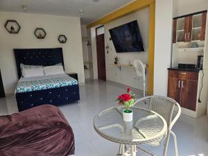 a living room with a bed and a table and a tv at Familiar 3er piso - La Merced in La Merced