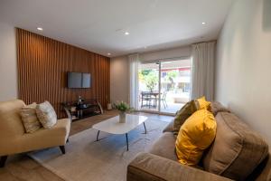 una sala de estar con un sofá y una mesa en Eagle Beach Steps Away Home, en Palm-Eagle Beach