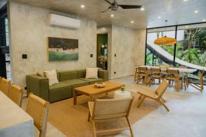 a living room with a green couch and a table at Manuel Antonio Tree House VIllas in Quepos +61 photos