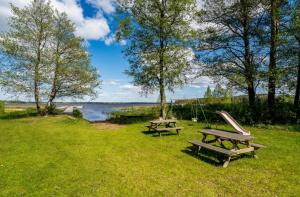 two picnic tables and a slide in the grass at Summer cottage near water with boat for rent in Åsbro