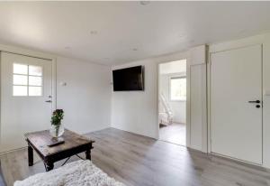 a living room with a table and a tv on the wall at Summer cottage near water with boat for rent in Åsbro