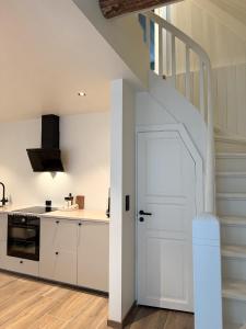 a kitchen with white cabinets and a white door at Varmt og hjemmekoselig Bergenshus med 2 leiligheter - i rolig smau i hjertet av Bergen in Bergen +45 photos