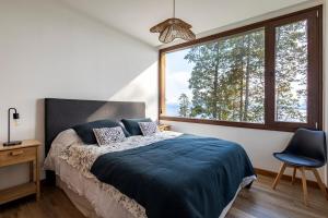 a bedroom with a bed and a large window at Departamento con vista al lago in San Carlos de Bariloche +14 photos