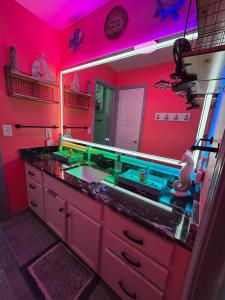 a red bathroom with a sink and a mirror at Boro Breeze Vacation Rental in Murfreesboro