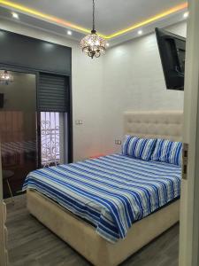 a bedroom with a bed and a flat screen tv at Villa entière in Azemmour