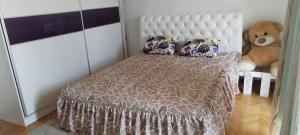 a bedroom with a bed and a teddy bear at Stamenkovic apartman in Vranje