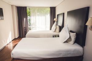 a hotel room with two beds and a window at Suites Parioli in Mexico City +62 photos