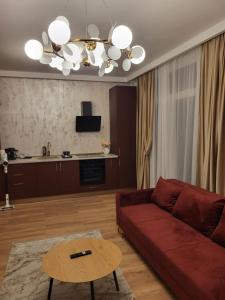 un salon avec un canapé rouge et une table dans l'établissement Sika Opulent Grand Apartment, à Arad