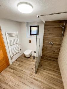 a bathroom with a toilet and a glass shower door at Villa Eterna in Tarčin +8 photos