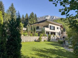 a house with a stone wall and a yard at Villa Eterna in Tarčin