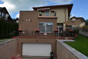 dom z białymi drzwiami garażowymi i balkonem w obiekcie Farkas Apartman w Siófoku