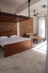 a bedroom with a large bed and a brick wall at Sithara Estate family Cottage in Ella