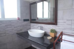 a bathroom with a sink and a mirror at Sithara Estate family Cottage in Ella