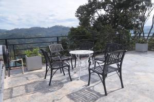 a group of chairs and a table on a balcony at Sithara Estate family Cottage in Ella