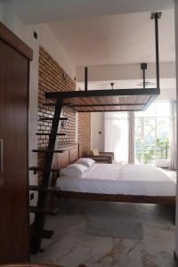 a bedroom with a loft bed and a brick wall at Sithara Estate family Cottage in Ella